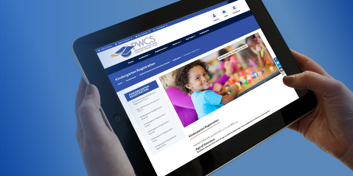 Someone holding a tablet, looking at the PWCS Kindergarten Registration website.